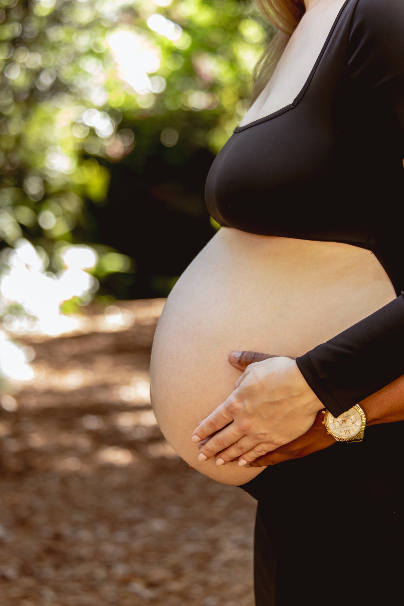 Close portrait of an expecting belly held by both parents